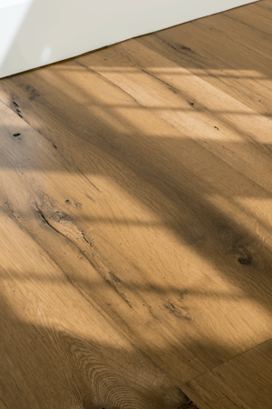 antique oak flooring closeup with sun cascading through windows