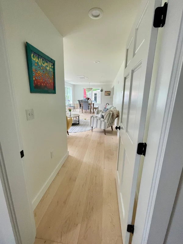 maple flooring in hallway leading to living room