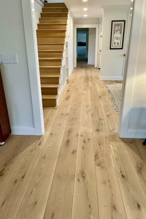 white oak wide plank flooring in hallway with stairs